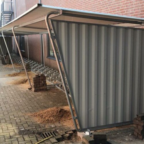 Fietsoverkapping Karin 36 Op de afbeelding zijn we bezig met de montage van een fietsoverkapping uit deze serie met een lengte van 16 meter. Een duurzame en zeer voordelige oplossing voor bedrijf en industrie.